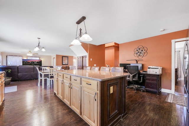 kitchen with open floor plan, light stone counters, light brown cabinets, a kitchen island, and dark wood-type flooring