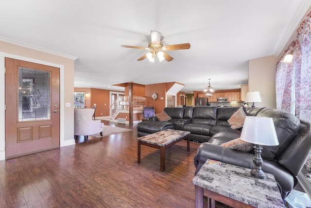 living room featuring dark wood-type flooring, crown molding, a ceiling fan, and baseboards