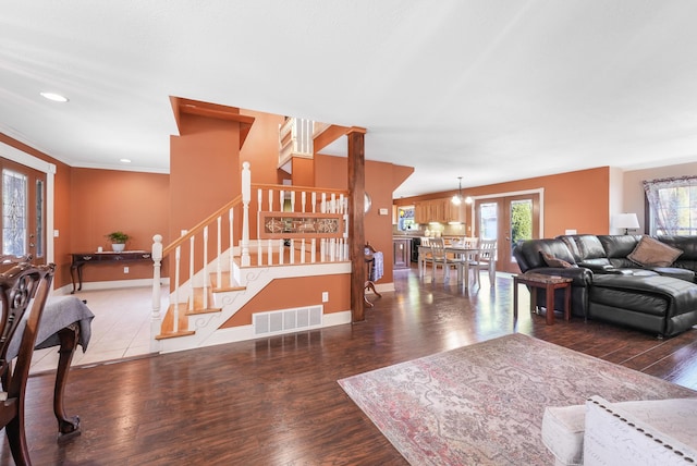 living room featuring stairway, wood finished floors, french doors, baseboards, and visible vents