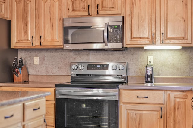 kitchen featuring light brown cabinets, backsplash, appliances with stainless steel finishes, and light countertops