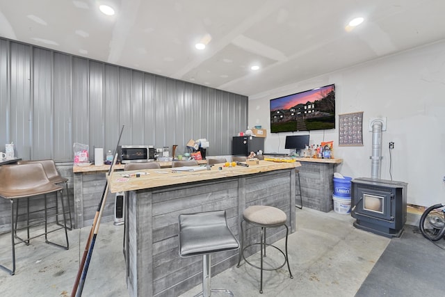 interior space with stainless steel microwave, concrete floors, and a wood stove