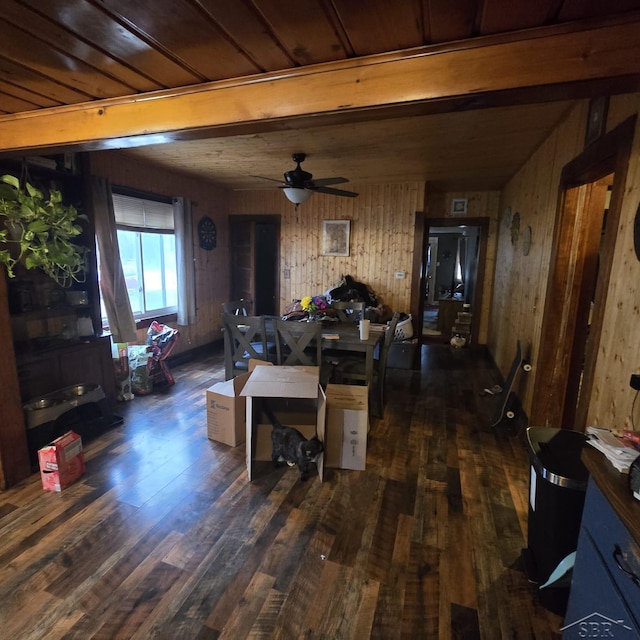 living room featuring ceiling fan, dark wood-type flooring, and wooden walls
