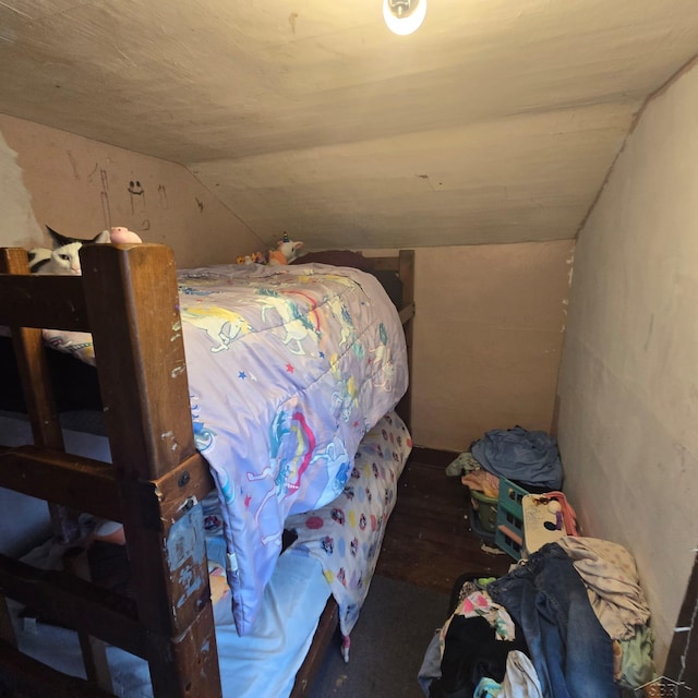 bedroom with lofted ceiling and wood finished floors