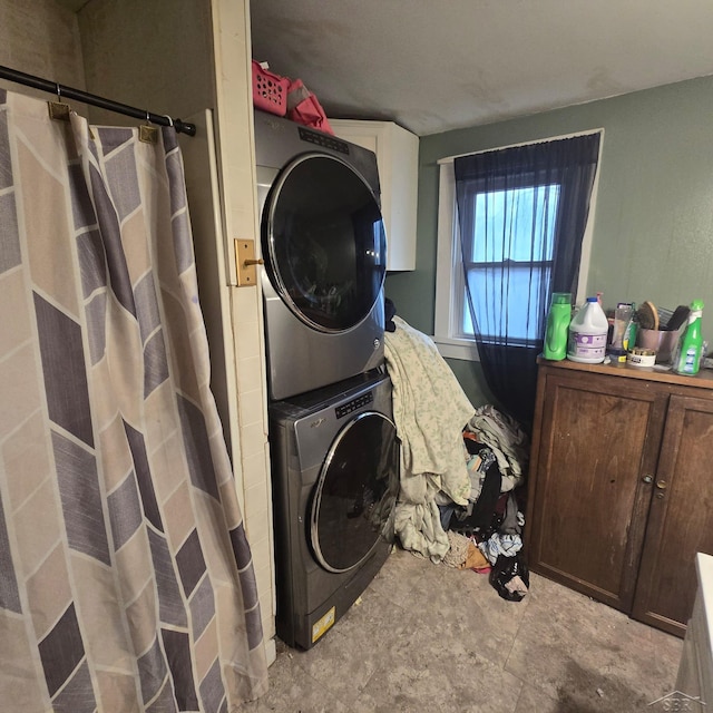 laundry area featuring stacked washer and clothes dryer and laundry area