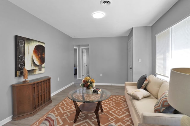 living area with baseboards and wood finished floors