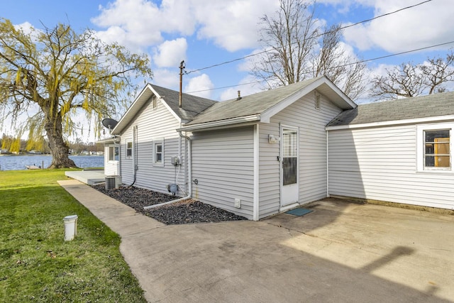 8033 S Portage Rd, Jackson, MI 49201 - view of property exterior featuring a patio area, a lawn, cooling unit, and a water view