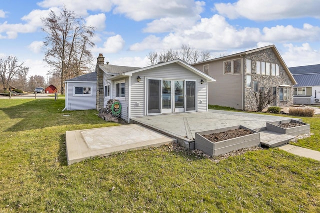 8033 S Portage Rd, Jackson, MI 49201 - rear view of property with a patio area, a chimney, and a yard