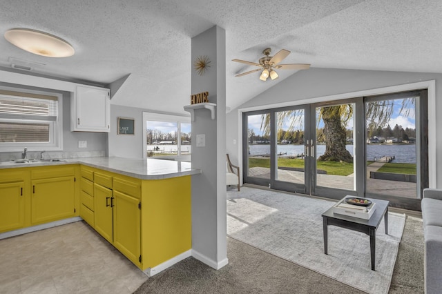 8033 S Portage Rd, Jackson, MI 49201 - kitchen featuring lofted ceiling, light countertops, a water view, a ceiling fan, and a sink