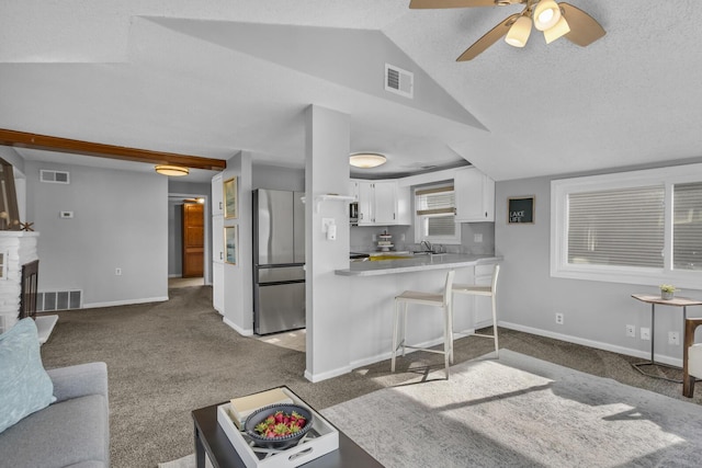 8033 S Portage Rd, Jackson, MI 49201 - carpeted living room with lofted ceiling, visible vents, baseboards, and ceiling fan