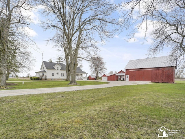 view of yard with an outbuilding, driveway, and a barn