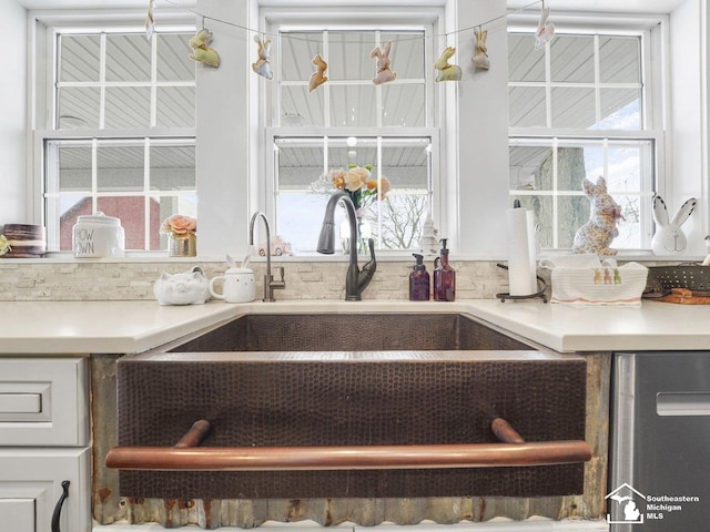 room details featuring white cabinets, light countertops, and a sink