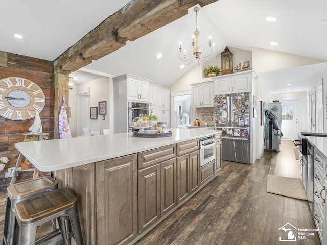 kitchen with tasteful backsplash, stainless steel appliances, dark wood-style floors, a center island, and lofted ceiling