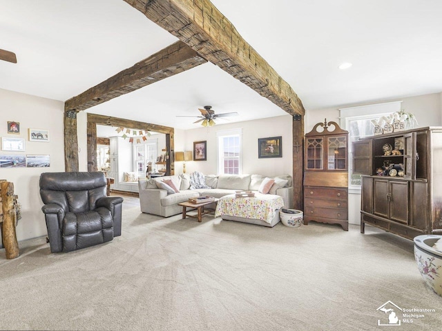 living room featuring beam ceiling, carpet, and ceiling fan