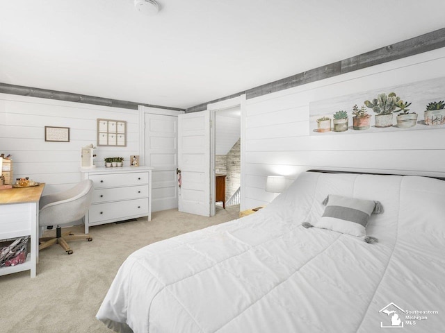 bedroom with wood walls and light colored carpet