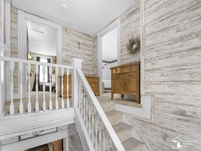 staircase featuring wood walls