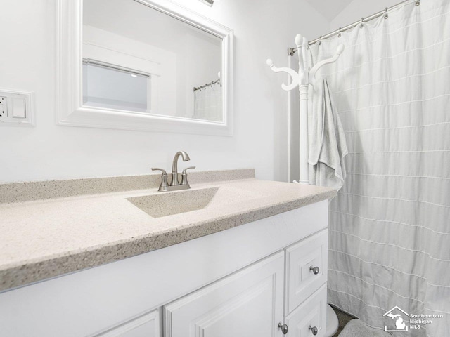 bathroom with curtained shower and vanity