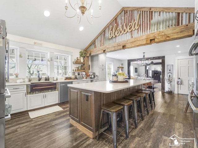 kitchen featuring an inviting chandelier, dishwasher, high vaulted ceiling, and a center island