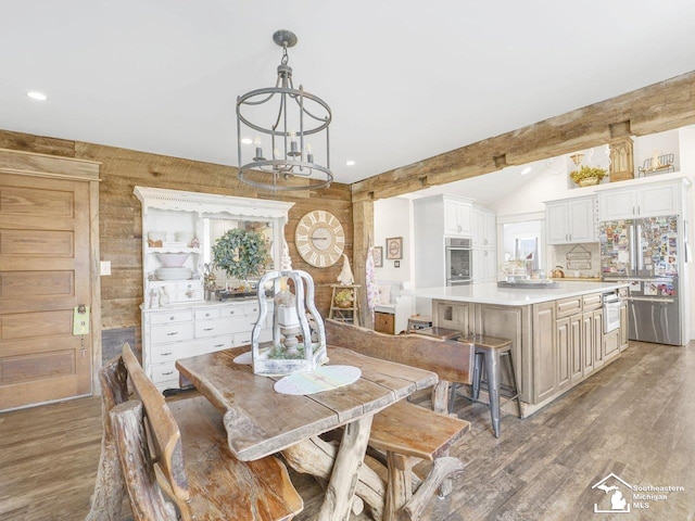 dining area with lofted ceiling with beams, recessed lighting, a chandelier, and wood finished floors