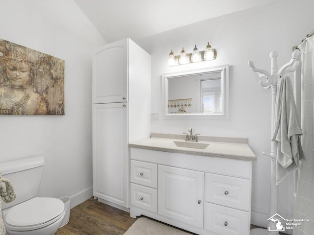 full bathroom featuring wood finished floors, toilet, vanity, and baseboards