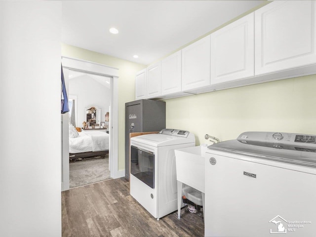 washroom featuring recessed lighting, wood finished floors, separate washer and dryer, and cabinet space