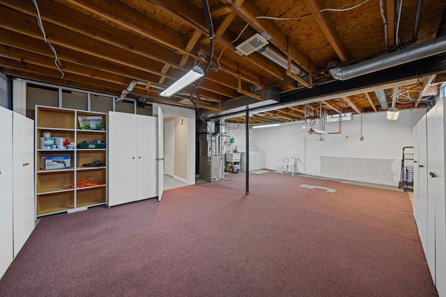 basement with visible vents, heating unit, washer / clothes dryer, and carpet flooring