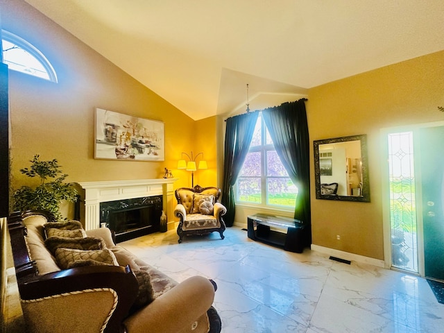 living area with a wealth of natural light, a premium fireplace, visible vents, and marble finish floor