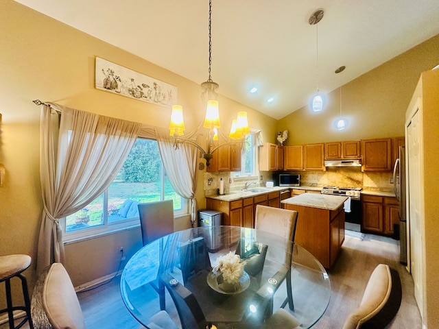 dining space with high vaulted ceiling, a notable chandelier, light wood-style floors, and recessed lighting