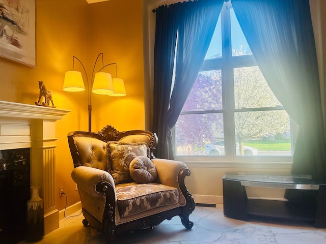 sitting room with baseboards, a fireplace, and marble finish floor