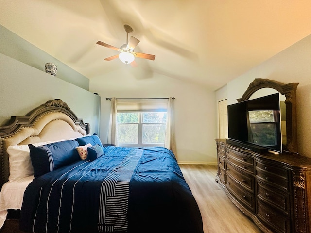 bedroom with baseboards, a ceiling fan, light wood-style flooring, and vaulted ceiling