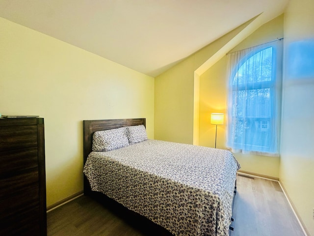 bedroom featuring vaulted ceiling and baseboards