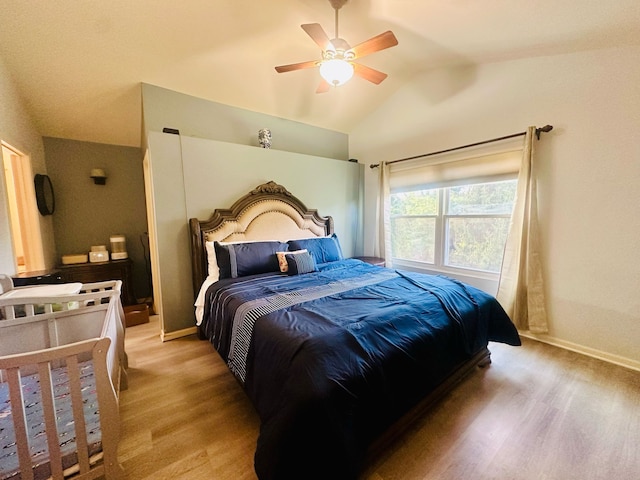 bedroom featuring lofted ceiling, ceiling fan, light wood-style flooring, and baseboards