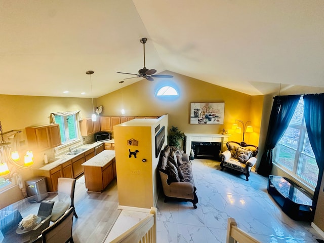 living room featuring ceiling fan, a premium fireplace, marble finish floor, and vaulted ceiling