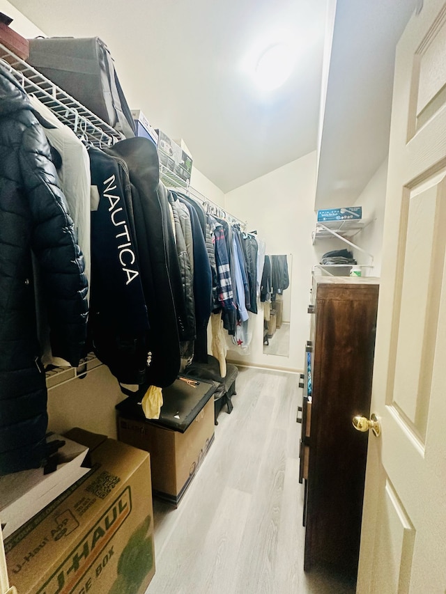 walk in closet with lofted ceiling and wood finished floors