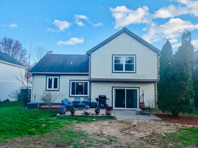 back of property with a patio, a chimney, central AC unit, and a yard