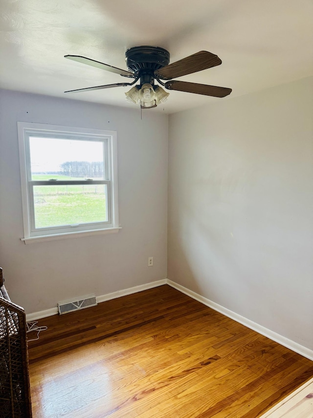 spare room with baseboards, a ceiling fan, visible vents, and light wood-style flooring