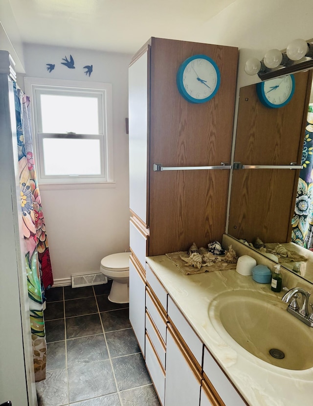 bathroom with baseboards, visible vents, vanity, and toilet