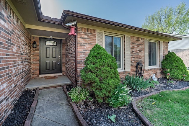 entrance to property featuring brick siding