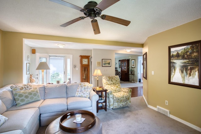 carpeted living room featuring ceiling fan, baseboards, and visible vents