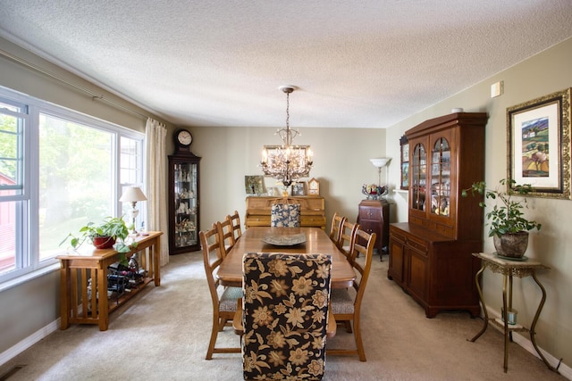 dining space with visible vents, baseboards, a chandelier, a textured ceiling, and light colored carpet