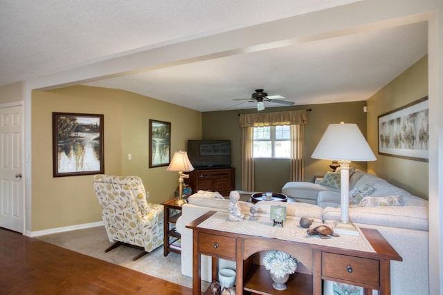 living area with wood finished floors, a ceiling fan, and baseboards