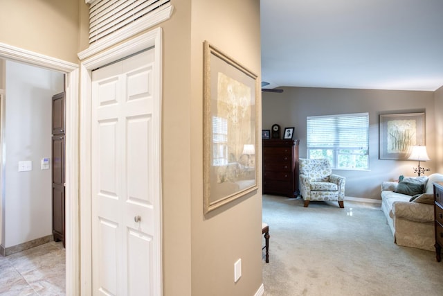 hallway featuring vaulted ceiling, baseboards, and carpet