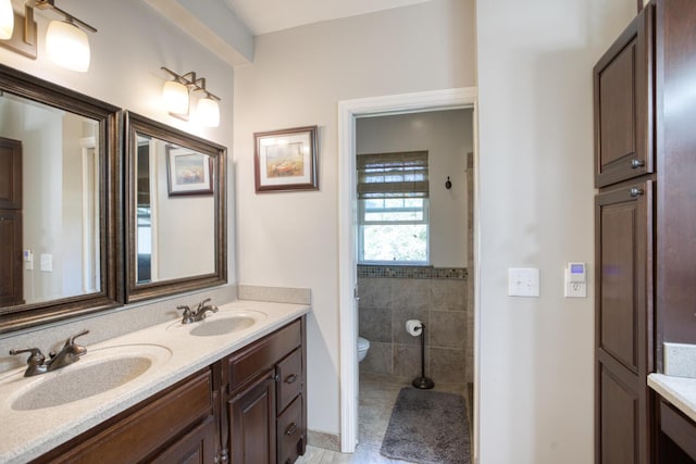 full bath featuring tile patterned floors, a sink, double vanity, and toilet