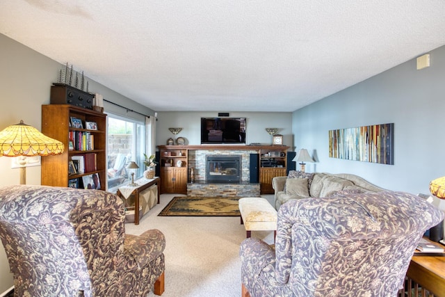 living room featuring a glass covered fireplace, a textured ceiling, and carpet