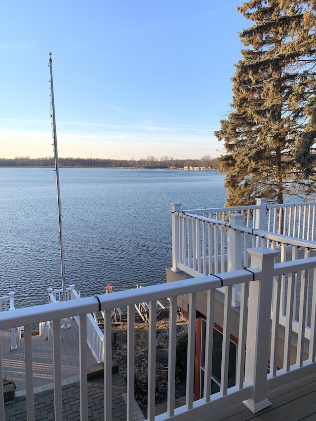 dock area with a water view and a balcony