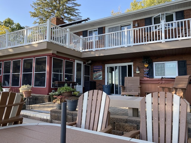 exterior space featuring brick siding and a balcony