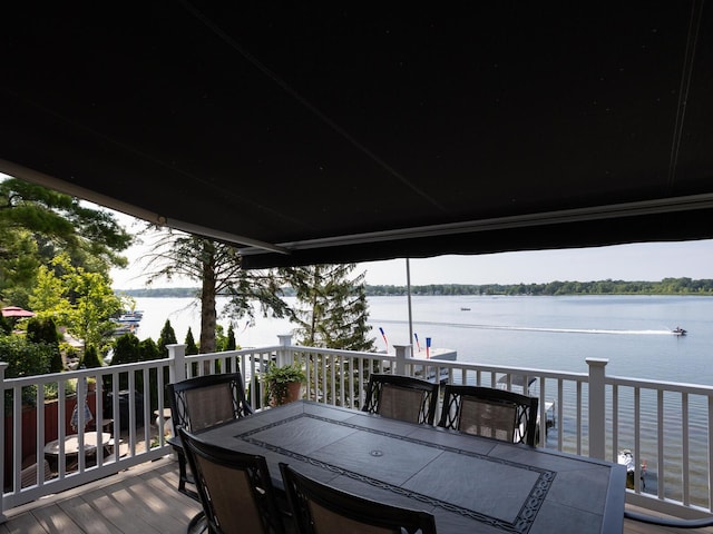 deck featuring outdoor dining area and a water view