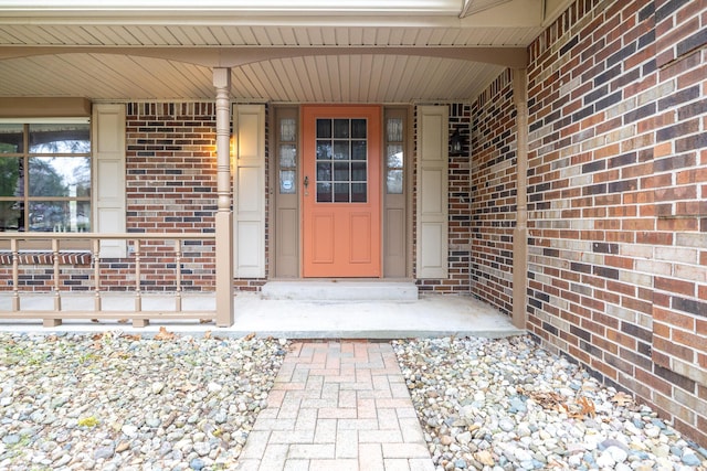 property entrance featuring brick siding and a porch