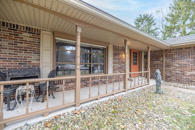 property entrance with brick siding and covered porch