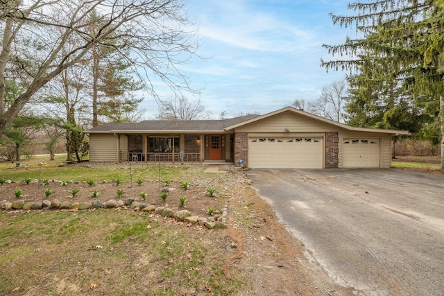 ranch-style home with brick siding, an attached garage, driveway, and a porch