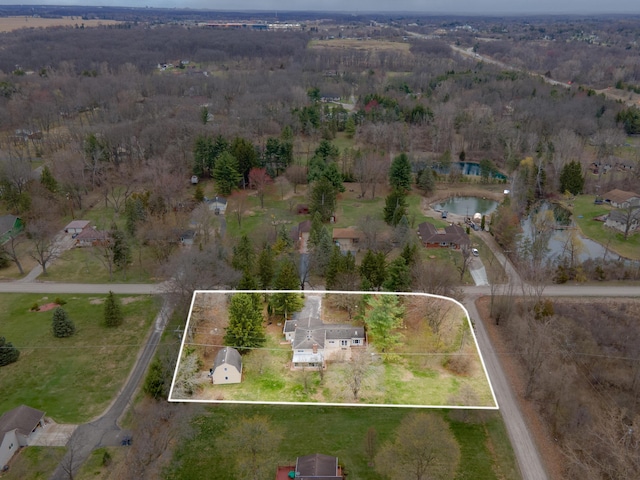 aerial view featuring a forest view and a water view